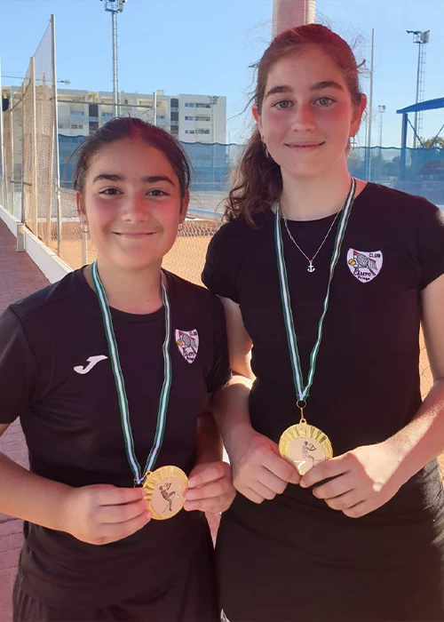 Campeonas de torneo femenino de tenis enseñando sus medallas