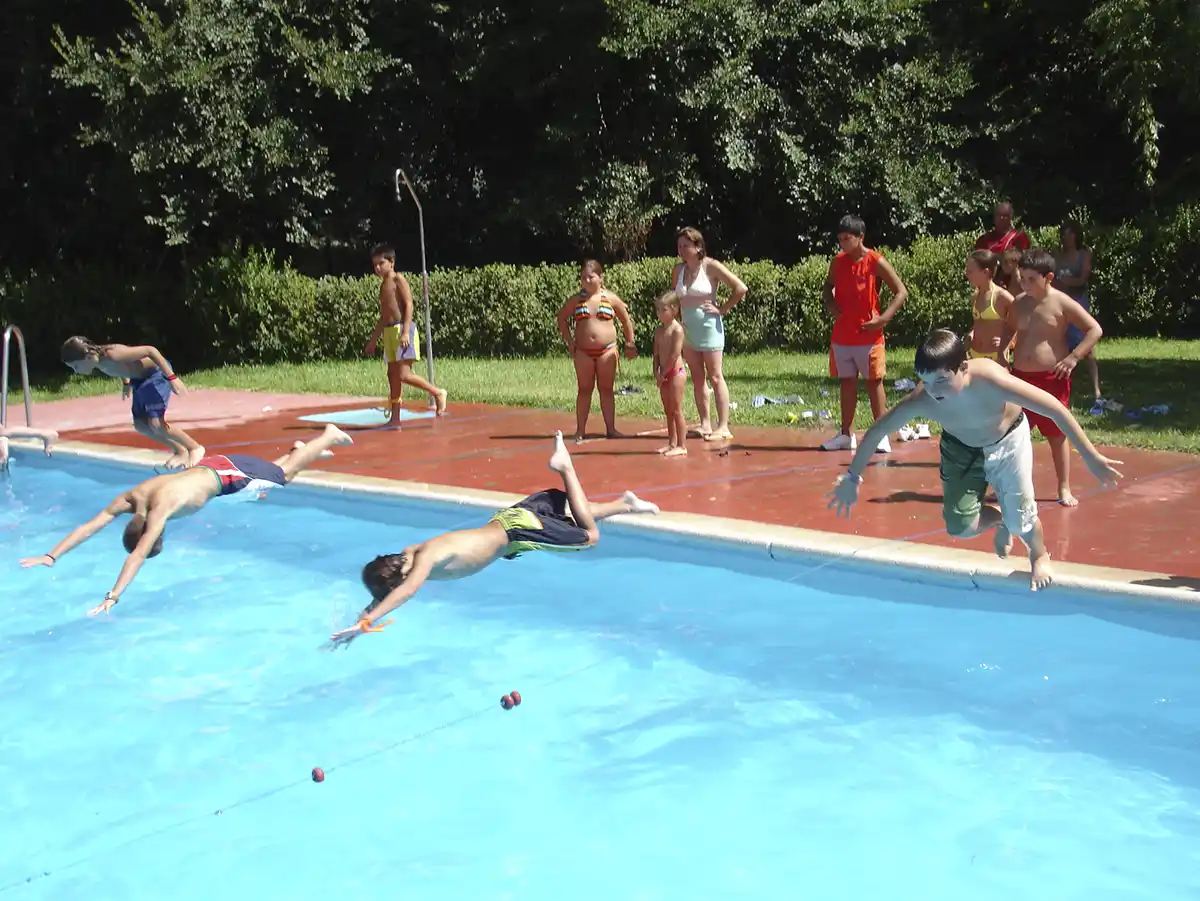 Niños tirándose a la piscina y disfrutando de la temporada de verano